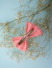 Load image into Gallery viewer, A rear view of the pink and white designed lace bow hair accessory with a clip, on a light blue background.