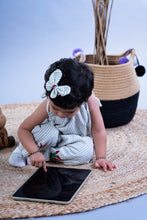 Load image into Gallery viewer, A baby girl wearing a cute butterfly accessories sitting on a jute mate and using tablet.
