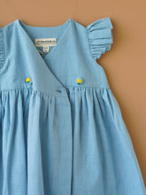 Load image into Gallery viewer, A designer light indigo flutter sleeve wrap dress kept upon a light peach background.