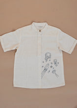 Load image into Gallery viewer, A white coloured Organic Cotton Doodle Shirt kidswear with space theme design kept on a biege coloured background