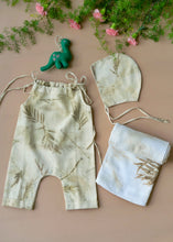 Load image into Gallery viewer, A beautiful unisex newborn gift hamper with swaddle made of wild silver oak with a toy kept upon a peach background with some flowers and leaves kept aside.