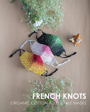 Load image into Gallery viewer, A colourful French knots organic cotton adjustable masks with some toy and flower aside.