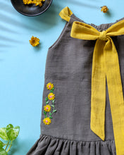 Load image into Gallery viewer, A beautiful dress with extra-long bow tie strap kept on a blue floor with some leaf, flower and needle aside.