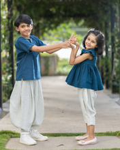 Load image into Gallery viewer, A young girl wearing elegant blue flutter sleeve top and cream balloon pant and young boy wearing blue and cream balloon pant posing together.