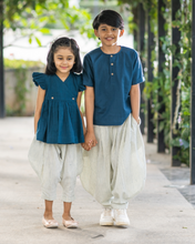 Load image into Gallery viewer, A young girl wearing elegant blue flutter sleeve top and cream balloon pant and young boy wearing blue and cream balloon pant posing together.