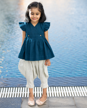 Load image into Gallery viewer, A young girl posing by wearing elegant blue flutter sleeve top and cream balloon pant with blur background.