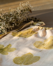 Load image into Gallery viewer, A cute baby girl dress made of eco-printed Indian maple leaves on it along with some flower aside.