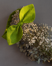 Load image into Gallery viewer, A green baby hair accessroy tied around flower.