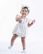 Load image into Gallery viewer, A baby posing by wearing white romper with matching hair accessory.