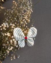 Load image into Gallery viewer, A cute butterfly hair accessory kept upon a flower.