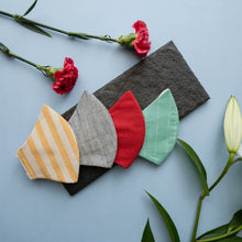 Load image into Gallery viewer, A stripped adjustable mask kept on a grey sheet with some flowers aside.