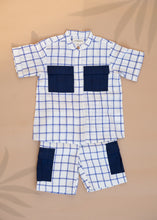 Load image into Gallery viewer, A set of Handwoven Cotton Co-ord set with Patch Pocket  kidswear with indigo checkmate design kept on a beige background
