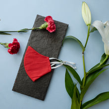 Load image into Gallery viewer, An adjustable mask kept on a grey sheet with some flowers aside.
