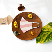 Load image into Gallery viewer, A beautiful, patterned face mask kept upon a round wooden log with some flower, leaf, toys and cards aside.
